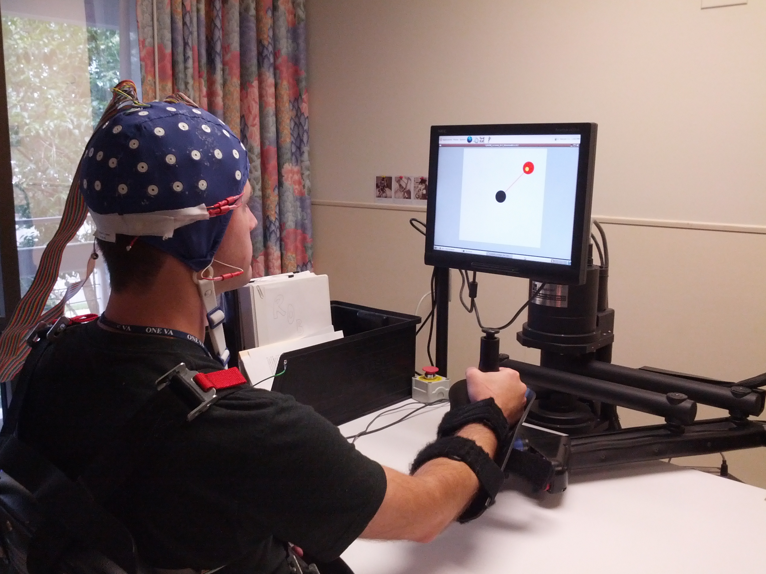 Research subject with EEG cap and therapy robot